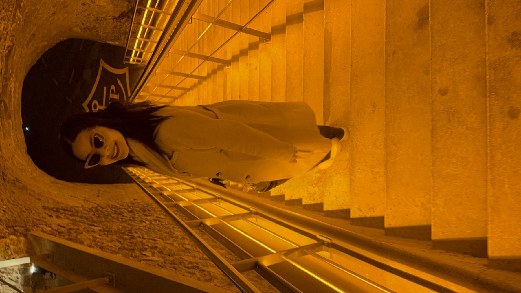 Eliza walking through the illuminated underground cellars at Veuve Clicquot